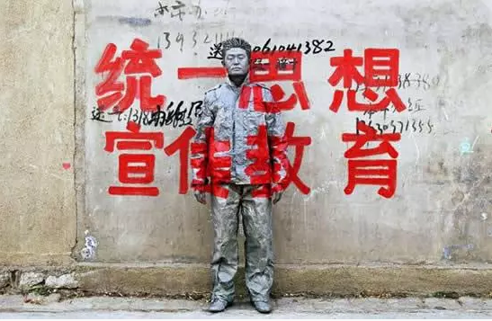 Liu Bolin camouflaged against a wall