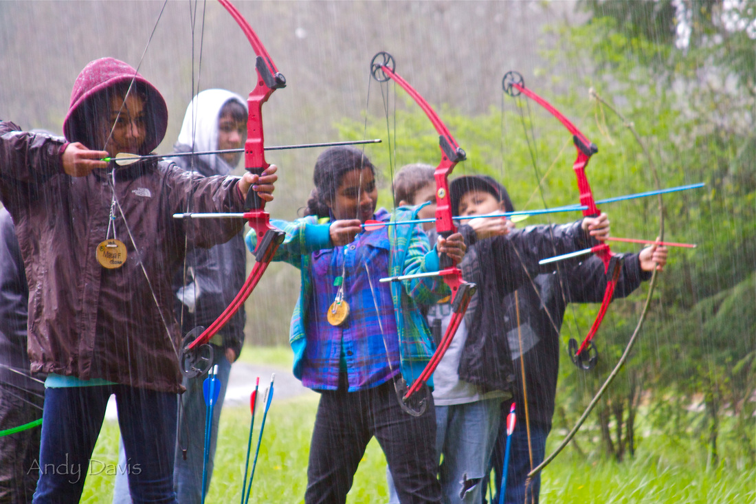 Students learning archery in the rain