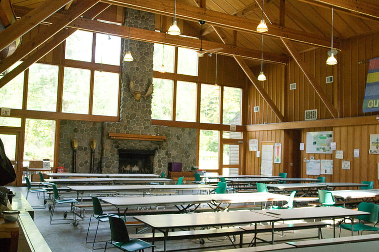 Angelos dining hall interior with long cafeteria-style tables